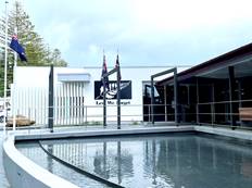 A building with a pool and a building with a flag
Description automatically generated