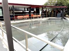 A group of people standing around a pool
Description automatically generated